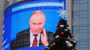 An electronic screen, which shows an image of Russian President Vladimir Putin and a quote from his annual televised year-end press conference and phone-in, is on display on the facade of a building behind a New Year and Christmas tree in a street in Moscow, Russia December 19, 2024. REUTERS/Shamil Zhumatov